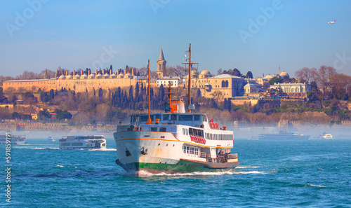 Water trail foaming behind a passenger ferry boat in Bosphorus on the background famous historical Topkapi Palace - Istanbul, Turkey