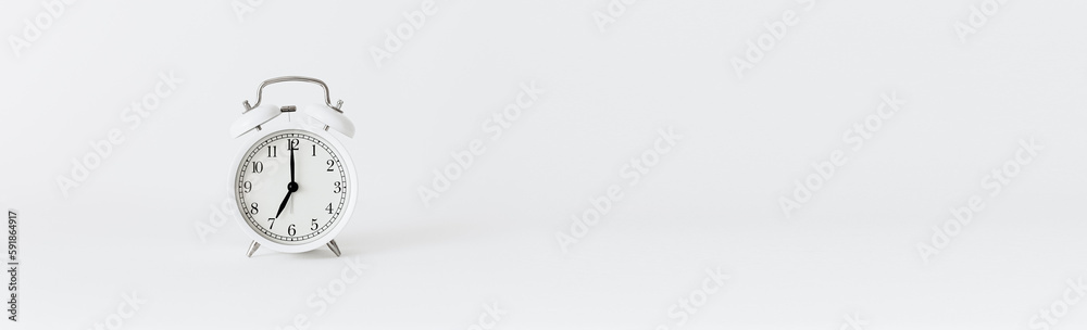 Classic white alarm clock on a white background. Alarm clock show 7 O'Clock with copy space.