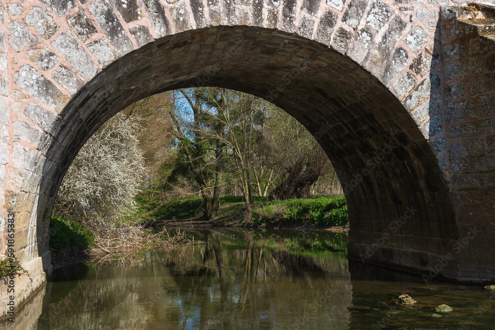 View through arch of Roman bridge on old royal road from Paris to Sens over Yerres river near medieval town of Brie-Comte-Robert. Built in 17th-18th c. recalls architects name, Romains brothers