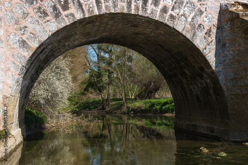 View through arch of Roman bridge on old royal road from Paris to Sens over Yerres river near medieval town of Brie-Comte-Robert. Built in 17th-18th c. recalls architects name  Romains brothers