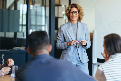 Mature business woman having a discussion with her team. Woman leading a meeting in an office