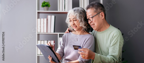 Senior couple using digital tablet and credit card to buying lif photo