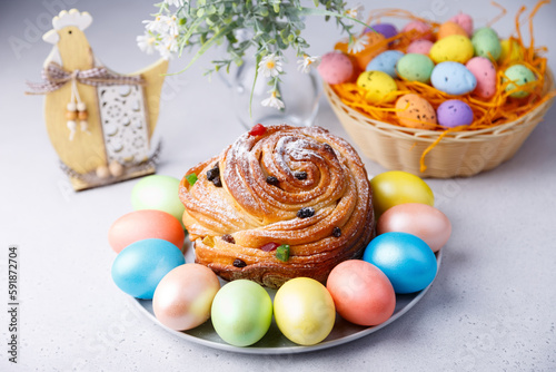 Craffin (Cruffin) with raisins and candied fruits sprinkled with powdered sugar. Traditional Easter Bread Kulich and painted eggs on a gray background. Easter Holiday. Close-up, selective focus. photo