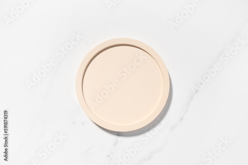 Beauty cosmetics product presentation flat lay mockup scene with beige circle shape on white marble table with copy space. Trendy sunlight,  top view. Studio photography.