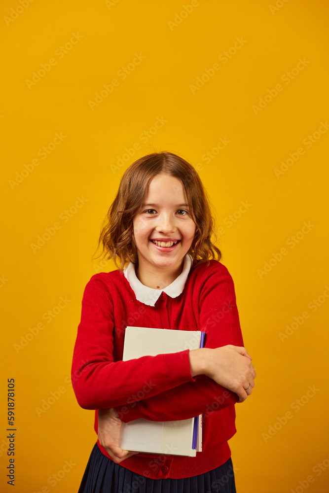 Happy teenage schoolgirl holding hugs the book in hand Happy teenage schoolgirl holding hugs the book in hand