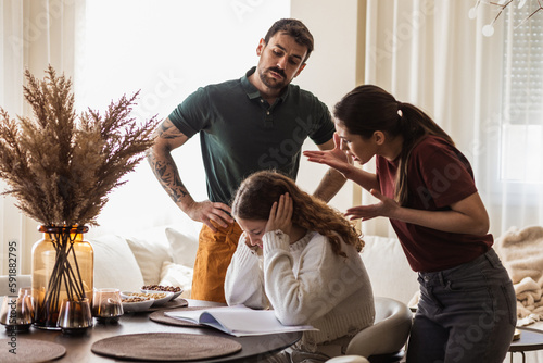 Parents yelling at their daughter, feeling disappointed with her grades.