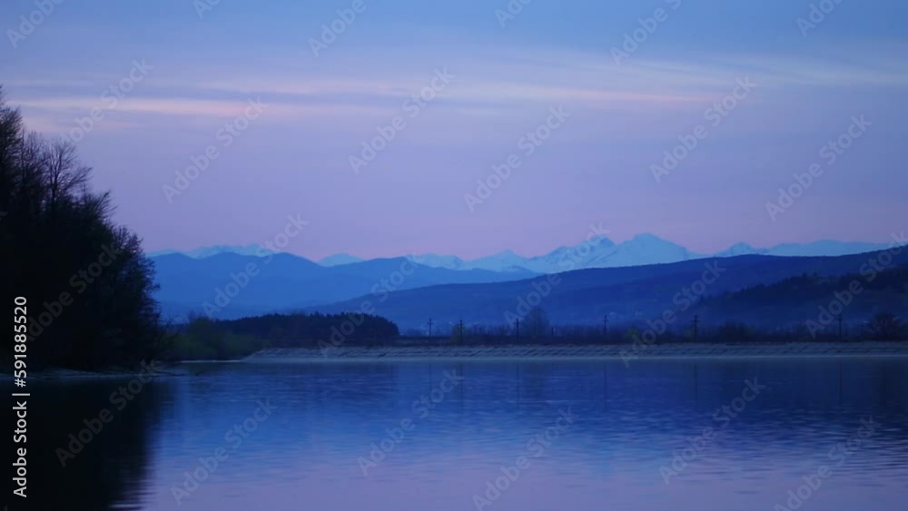 Beautiful shot of a lake in the background of mountains at the blue hour Beautiful shot of a lake in the background of mountains at the blue hour