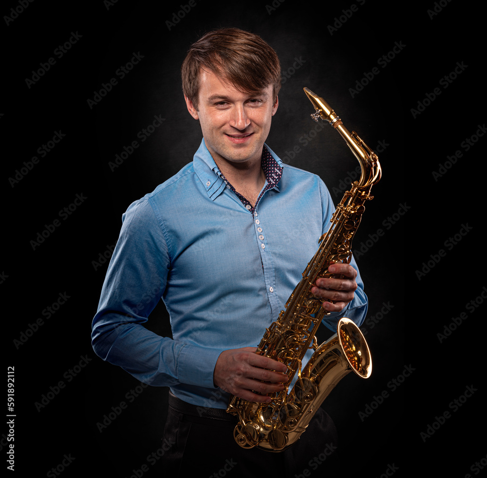 Fototapeta premium Saxophonist on a black background close-up.