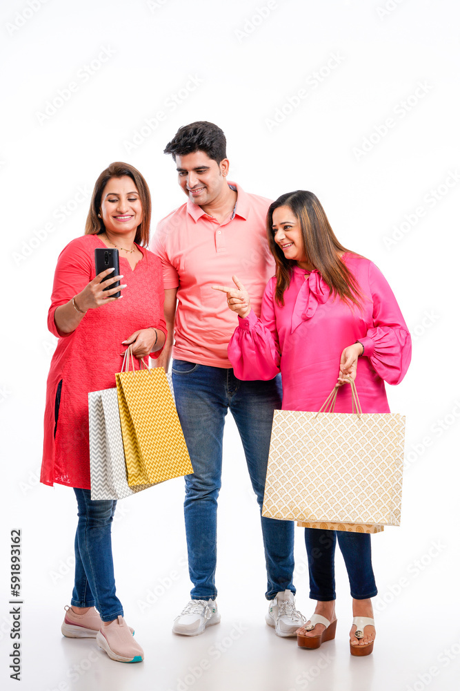 Indian people group holding shopping bags and using smartphone on white background. Indian people group holding shopping bags and using smartphone on white background.