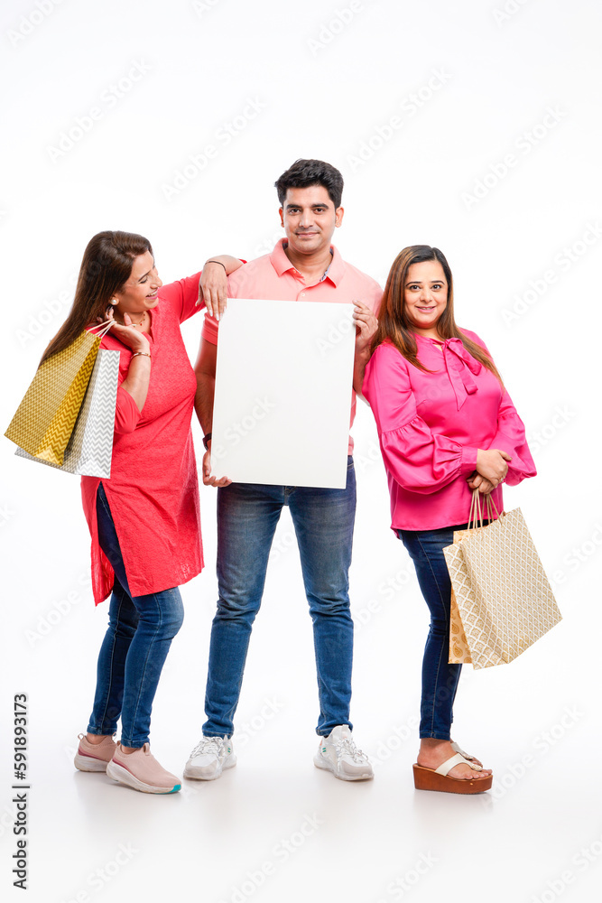 Indian people group holding shopping bags and showing white board with copy space Indian people group holding shopping bags and showing white board with copy space