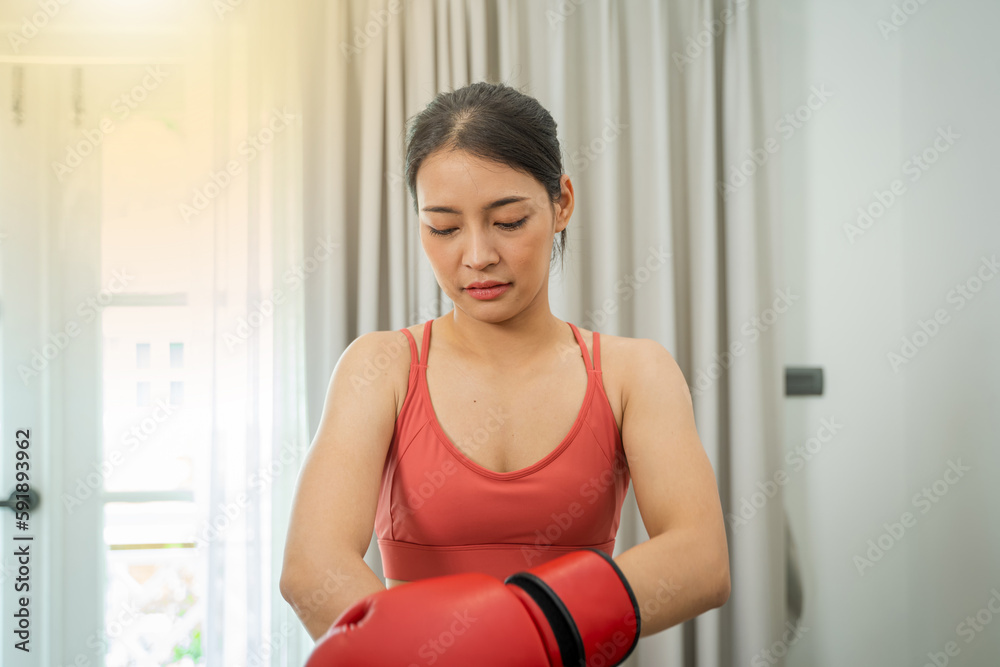 Beautiful woman exercising with boxing on living room at home,Sport woman with boxing gloves.