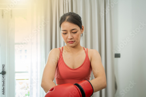 Beautiful woman exercising with boxing on living room at home,Sport woman with boxing gloves.