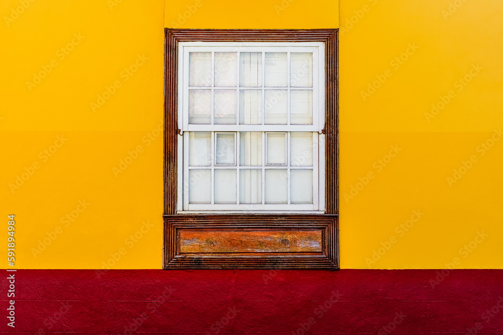 Ventana de madera en fachada amarillo y rojo de estilo colonial Ventana de madera en fachada amarillo y rojo de estilo colonial