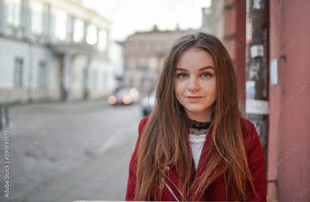 Close up Face of Beautiful Young Girl in Vilnius Old Town, Lithuania. Wearing Red jacket and Black Trousers. Beautiful Spring Day