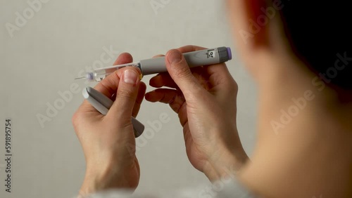 Diabetic woman with insulin injection pen, close-up photo