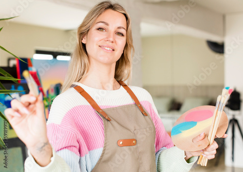pretty young woman painting an artwork. artist concept. house interior design