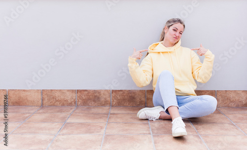 pretty caucasian sitting woman looking proud, arrogant, happy, surprised and satisfied, pointing to self, feeling like a winner