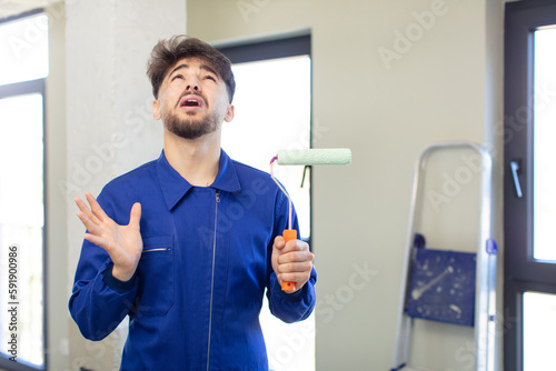 Fotografie young handsome man screaming with hands up in the air