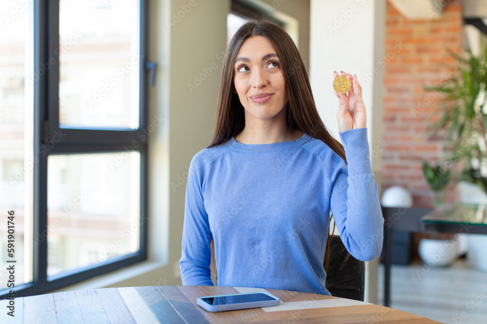 smiling with a happy, confident expression with hand on chin. virtual money concept smiling with a happy, confident expression with hand on chin. virtual money concept