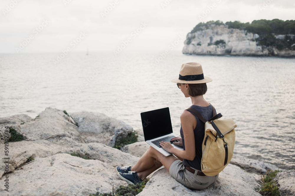 Young woman using laptop computer, working by the sea, Freelance work, vacations, business people, technologies, distance studying, freelancer lifestyle, meeting online, web call concept