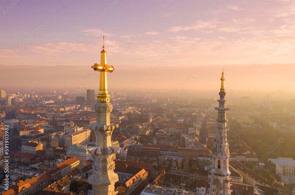 Obraz premium Golden Cross of Zagreb Cathedral in Croatia. It is on the Kaptol, is a Roman Catholic institution and the tallest building in Croatia. Sacral building in Gothic style. Cityscape in Background