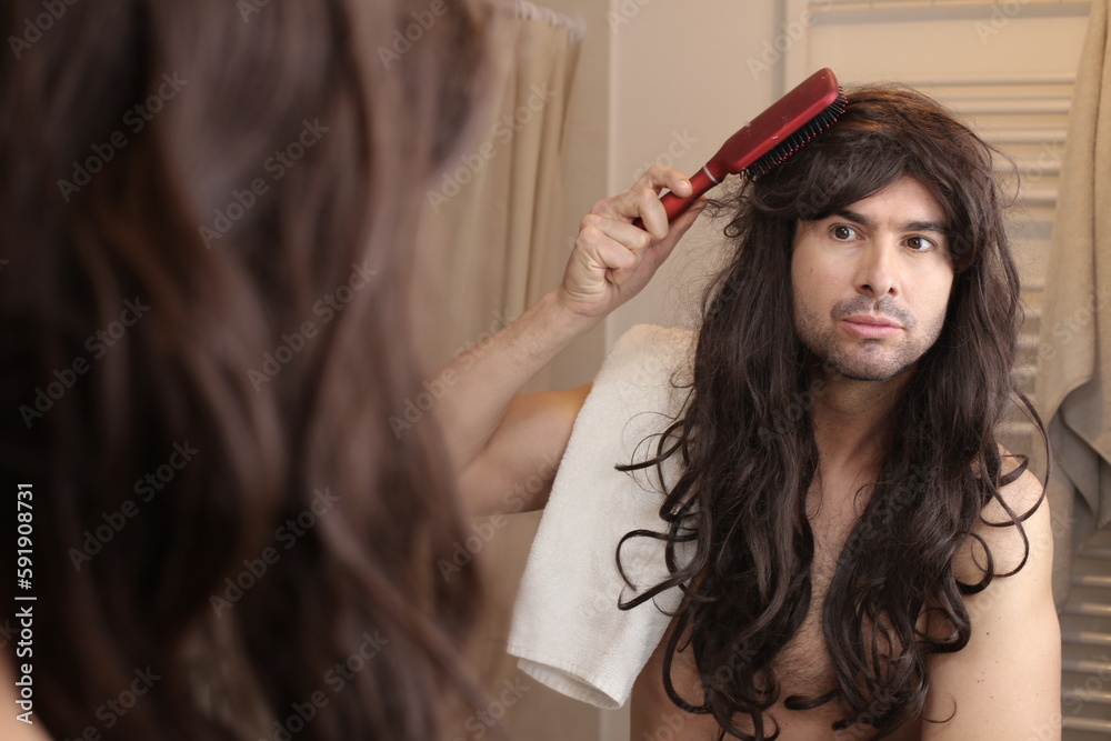 Naklejka premium Man with very long hairstyle using a hairbrush 