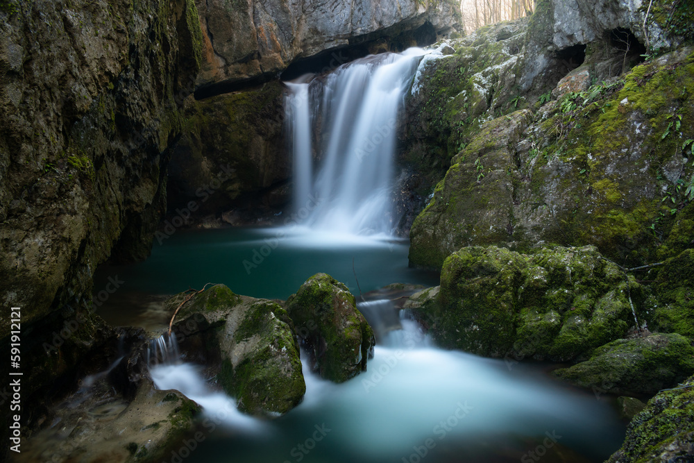 Fototapeta premium Waterfall with mossy rocks in forest, Svrakava waterfall near Banja Luka