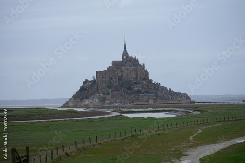 Mont Saint Michel from afar with green farmland in foreground, Normandy region, France
