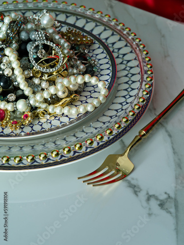 Close up view of different sorts of jewelry is on the plate ready to be eaten photo