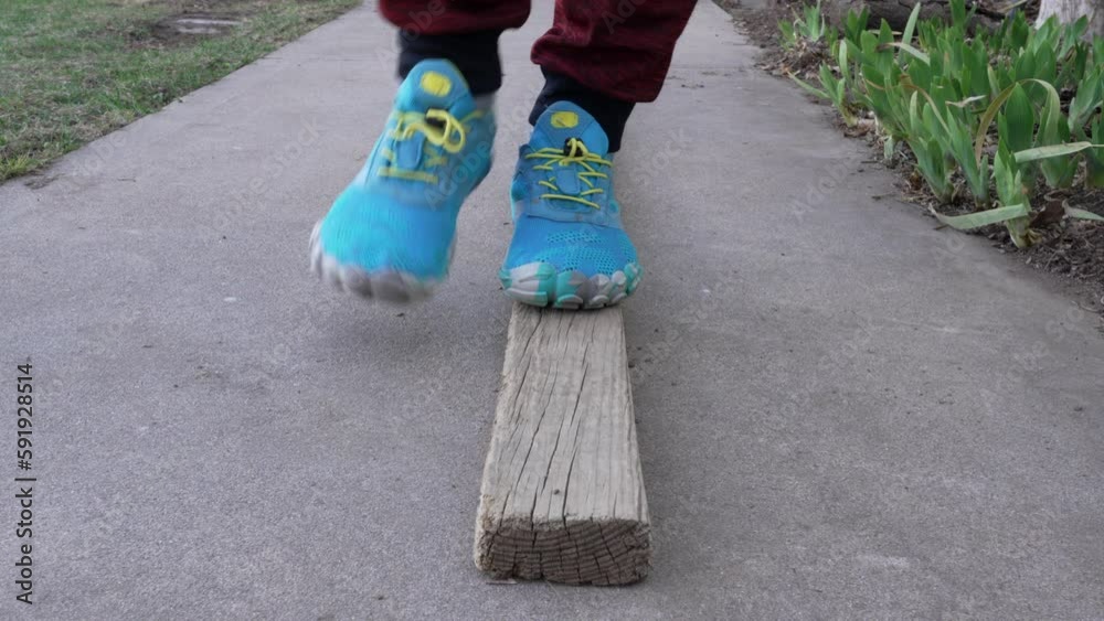 balance exercise feet of a man walking back and forth on a wobbly 2x4