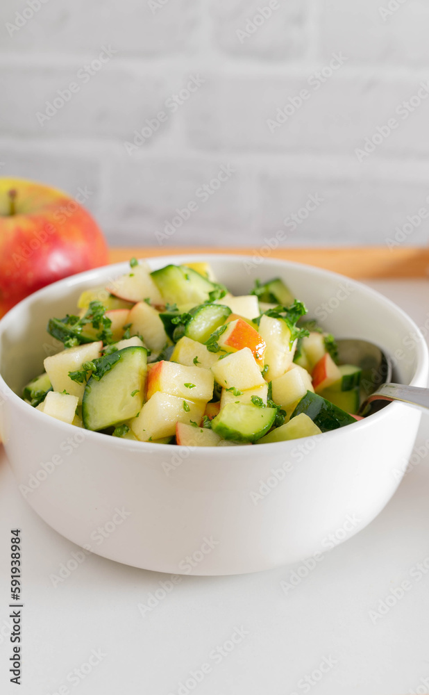 Raw fruit and vegetable salad with cubed cucumber and apples marinated with honey, lemon juice, olive oil and parsley