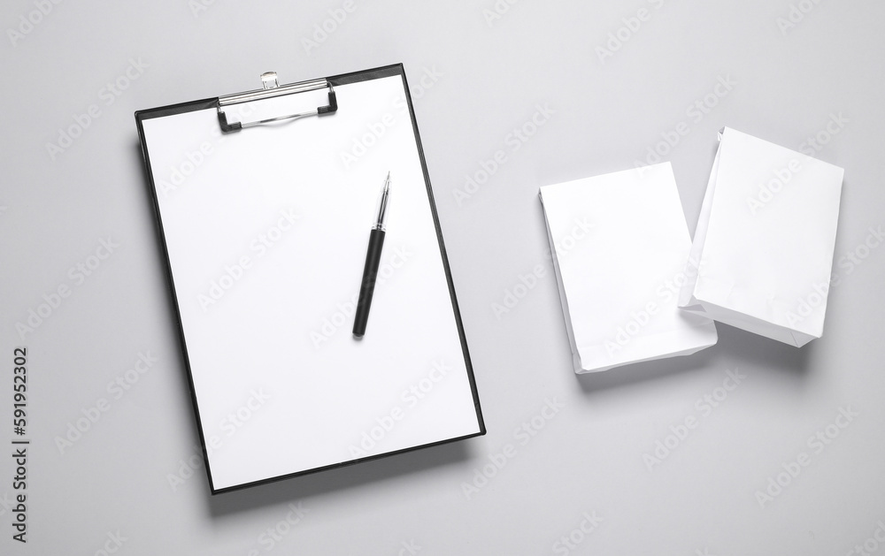 Clipboard with Two white packs mockup on gray background. Template for design. Business concept. Food delivery Clipboard with Two white packs mockup on gray background. Template for design. Business concept. Food delivery