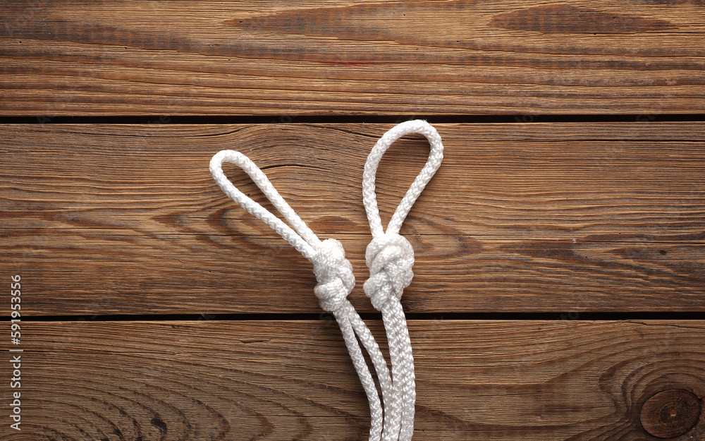 Rope with a knots and loops on wooden background Rope with a knots and loops on wooden background