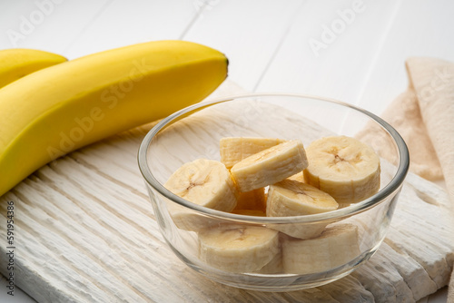 Fresh bananas sliced in glass bowl. Healthy natural vitamin snack with copy space