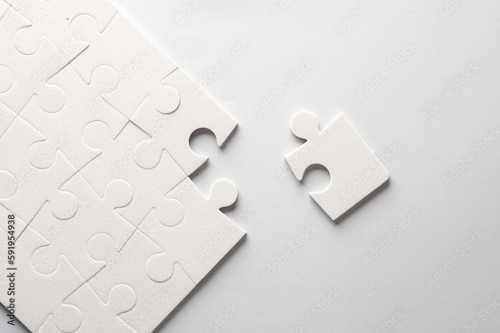 Obraz premium White jigsaw puzzle pieces on a gray background.