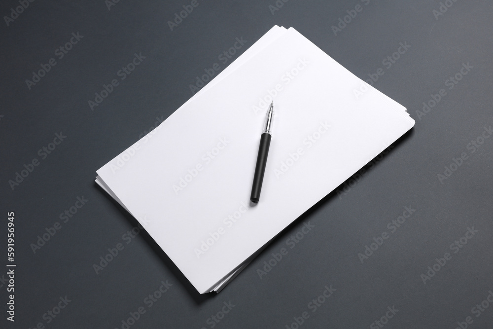 Sack of white a4 paper with a pen on a dark background. Business concept Sack of white a4 paper with a pen on a dark background. Business concept