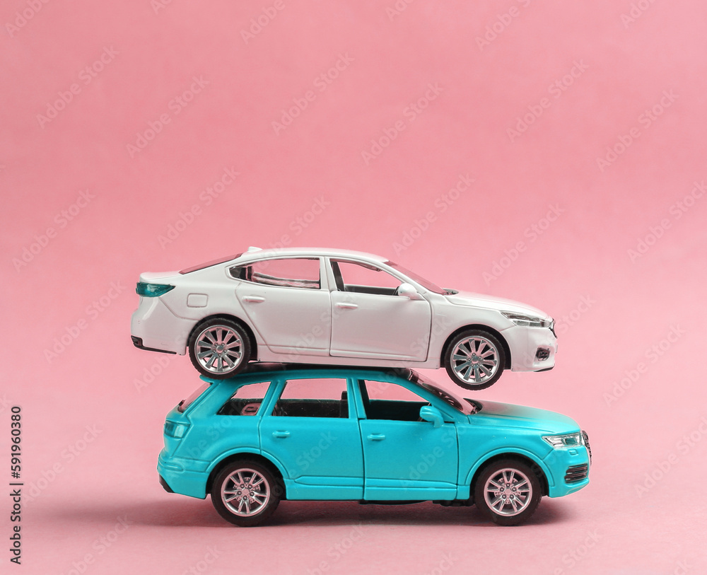 Two toy car models on a pink background Two toy car models on a pink background