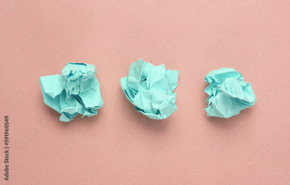 Pink crumpled sheets of paper on a light pink background. Minimal concept