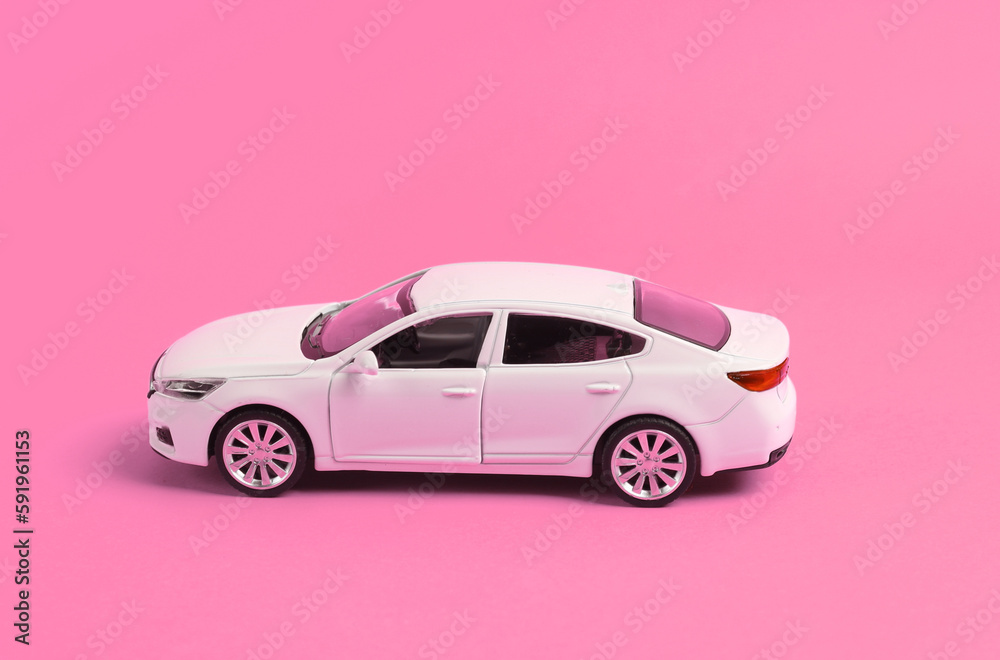 Mini model of white toy car on pink background