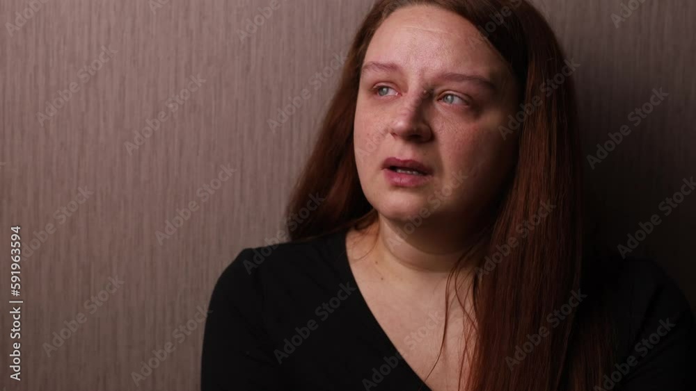 Sad woman bitterly cry near room wall. Tears roll down cheeks, tearful eyes and swollen face. Splash out emotions, sob violently. Emotional breakdown, mental health problems. Depression and hysterics.