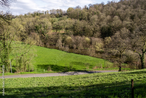 View of the countryside in France. Green hills with grass and trees. Sunny day.