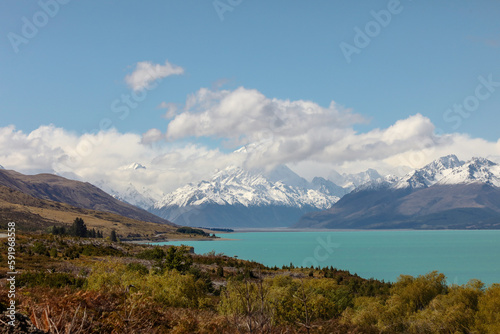 The magnificent, snow-covered Aoroki or Mount Cook, the highest mountain in New Zealand, is seen from an azure Lake Pukaki
