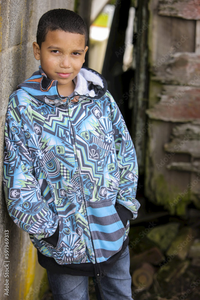 Portrait Of A Young Boy Standing Against A Concrete Wall; Oregon, United States Of America Portrait Of A Young Boy Standing Against A Concrete Wall; Oregon, United States Of America