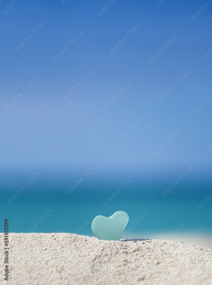 A Turquoise Heart Shaped Sea Glass In The Sand At The Beach; Honolulu, Oahu Hawaii, United States Of America A Turquoise Heart Shaped Sea Glass In The Sand At The Beach; Honolulu, Oahu Hawaii, United States Of America