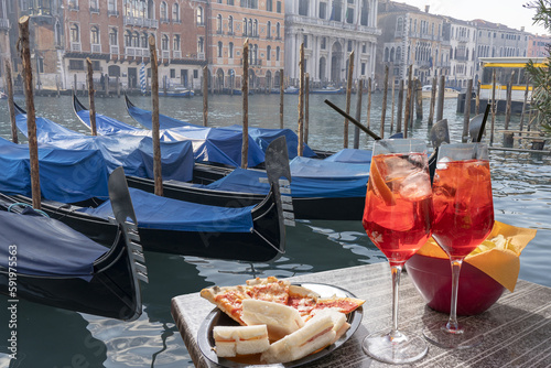 Spritz for two with snacks in Venice with the backdrop of the Canale Grande and moored gondolas. © cesaresent