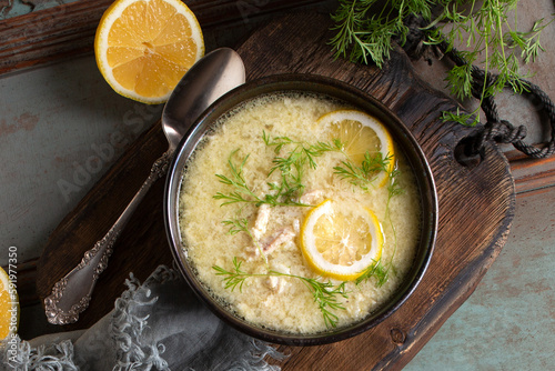bowl with traditional greek chicken avgolemono soup on the table
