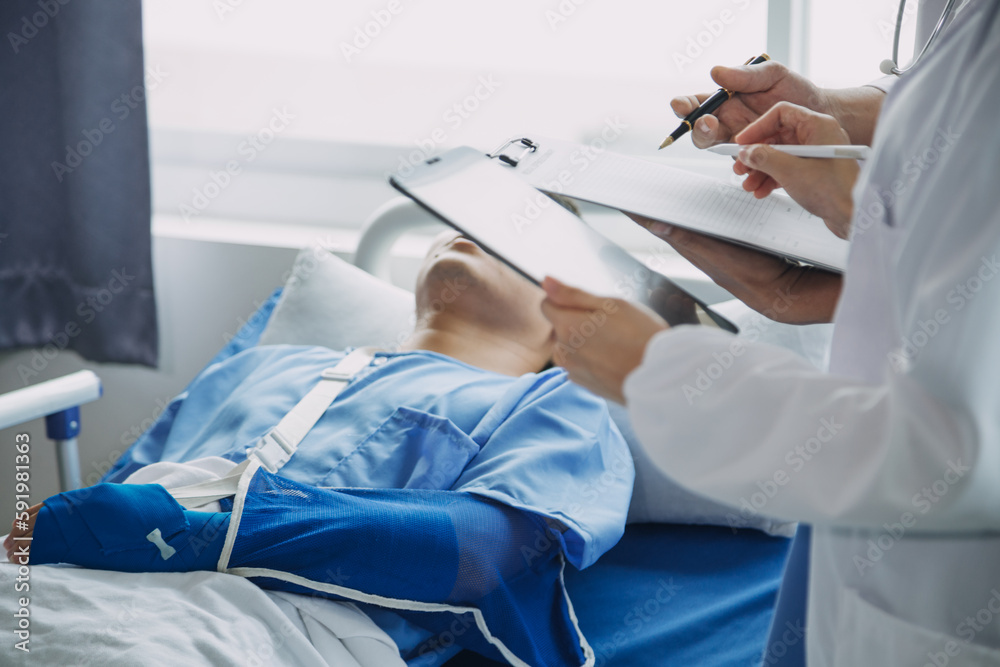 Injured patient showing doctor broken wrist and arm with bandage in hospital office or emergency room. Sprain, stress fracture or repetitive strain injury in hand. Nurse helping customer. First aid. Injured patient showing doctor broken wrist and arm with bandage in hospital office or emergency room. Sprain, stress fracture or repetitive strain injury in hand. Nurse helping customer. First aid.