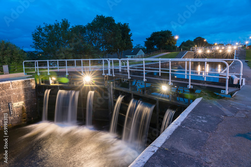At dusk, lights illuminate the Caledonian Canal locks in Inverness, Scotland; Inverness, Scotland
