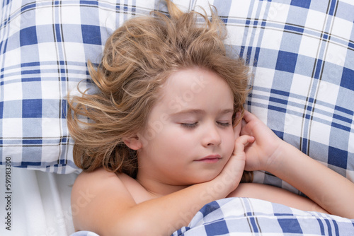 Quiet sleep. Kid sleeping in bed. Child sleeping in bed under blanket. Kid lying on pillow, child rest asleep, enjoy healthy sleep or nap. photo