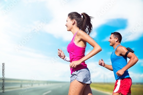 Sporty young happy couple run together outdoors.